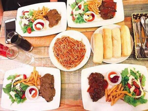 Luna steak ảnh 2 - Khung hình ghi lại khoảnh khắc những miếng bít tết vàng ươm trên chảo gang nóng hổi, tỏa làn khói thơm phức giữa không gian ấm cúng.