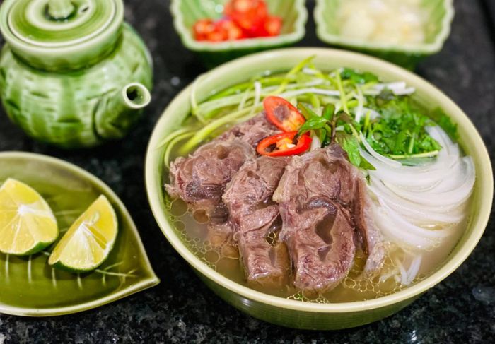 Phở bò 23 ảnh 2 - Góc nhìn cận cảnh đầy mê hoặc: lớp thịt bò tái mỏng tang, sợi hành tây trắng ngần và những cọng ngò xanh tươi hòa quyện trong nước dùng trong vắt.