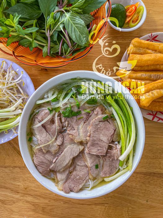 Phở Hùng Ngân ảnh 1 - Khoảnh khắc nghệ thuật tôn vinh tô phở vàng ươm, nước dùng trong vắt lấp lánh dưới ánh đèn, thịt bò tái hồng như bức tranh ẩm thực sống động.