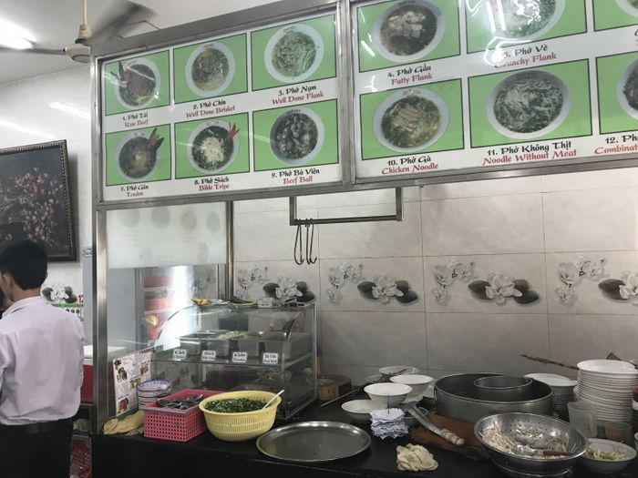 Phở Hảo ảnh 2 - Góc nhìn chân thực về tô phở thơm ngon, với lớp thịt tái mỏng manh điểm xuyết hành lá xanh tươi trên nền nước dùng trong vắt.