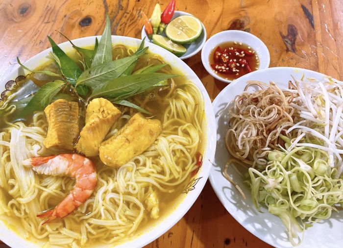 Hình ảnh tô bún cá Châu Đốc với bông điên điển vàng tươi