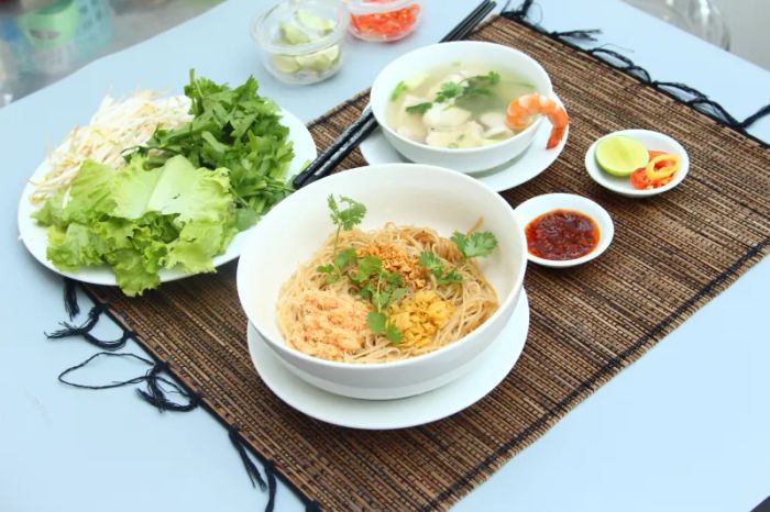 Hình ảnh tô hủ tiếu thập cẩm tại Hủ Tiếu Cá Chế Khiếm - sắc vàng ươm của nước dùng, hải sản tươi bốc khói nghi ngút