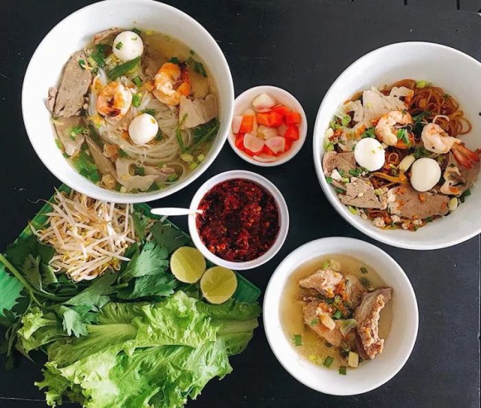 Không gian ấm cúng tại quán với những tô hủ tiếu nóng hổi, điểm xuyết sắc xanh của hành ngò và đỏ tươi của ớt