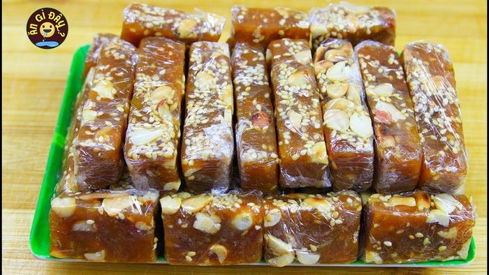 Kẹo chuối ảnh 1 - Tác phẩm nghệ thuật ẩm thực với lớp vỏ nâu bóng điểm xuyến hạt vừng đen, cắt lát để lộ lớp chuối dẻo bên trong
