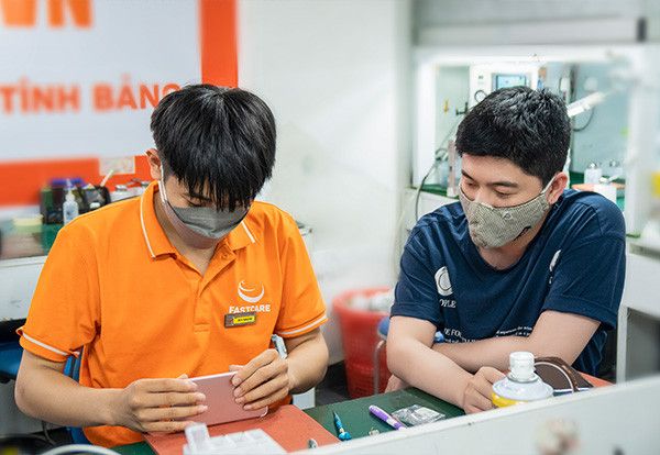 Hình ảnh khách hàng đang quan sát quy trình sửa chữa minh bạch tại không gian hiện đại của FASTCARE