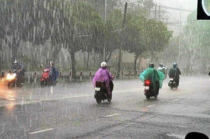 Dòng nước mưa cuồn cuộn chảy về miệng cống trên con đường ngập nước - Ảnh minh họa