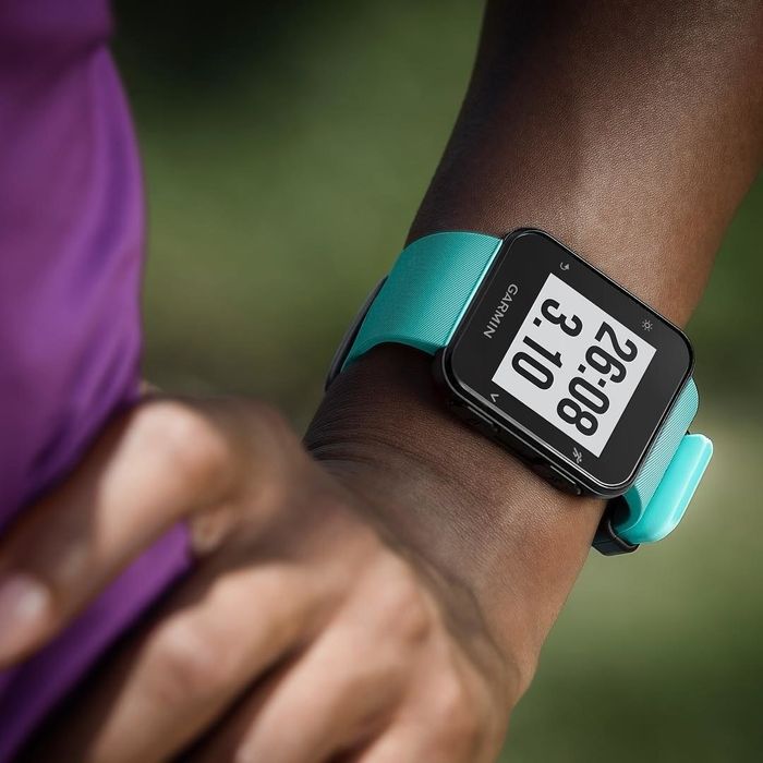 Closeup of a person’s wrist wearing the Garmin Forerunner 35 GPS running watch, showcasing its sleek design.
