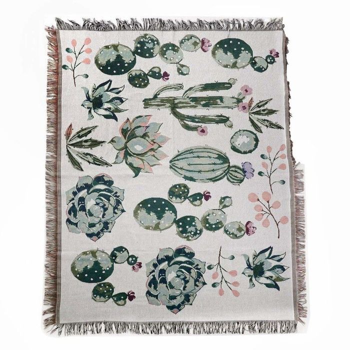 A cactus-themed blanket with tassels