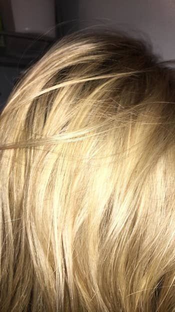 A reviewer's warm-toned blonde hair before using the product