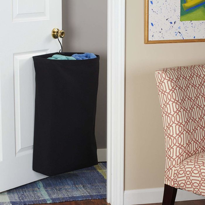 The hanging cotton canvas laundry bag with clothes inside.