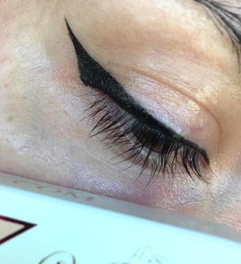 a reviewer revealing how effortlessly their cat eye turned out using the tool