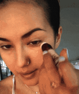 A gif of a Mytour editor applying the concealer under her eyes.
