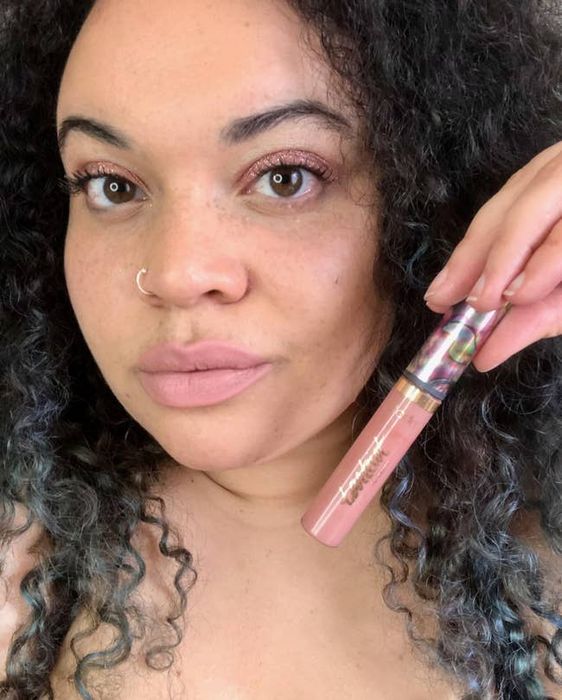 Mytour Shopping reviewer holding the light pink lip paint, perfectly matching their lips