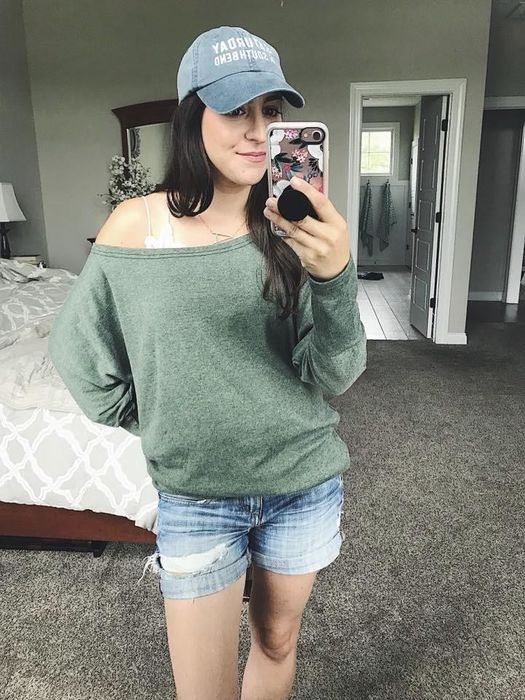 A reviewer wearing the tunic off the shoulder, layered over a tank top for added comfort