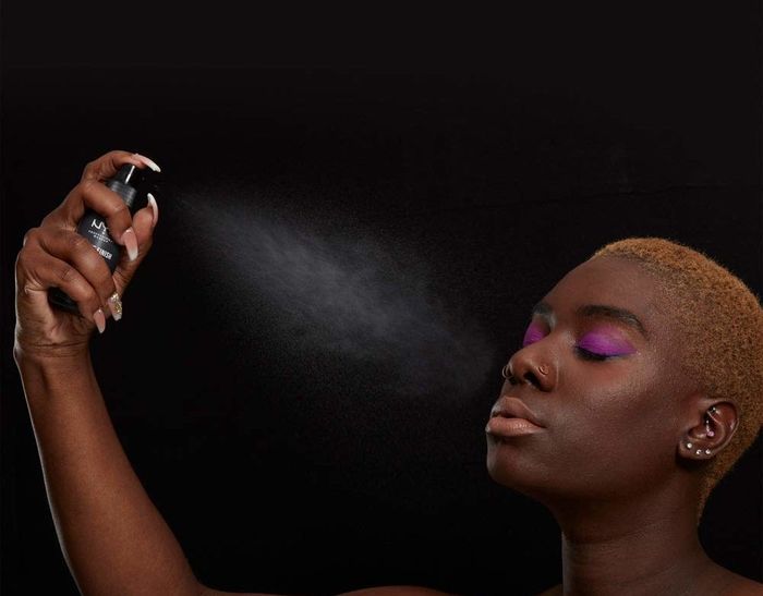 model applying the setting spray