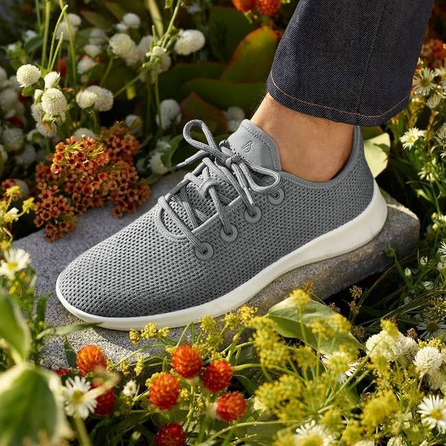 model wearing the grey knit lace-up sneakers with a white sole
