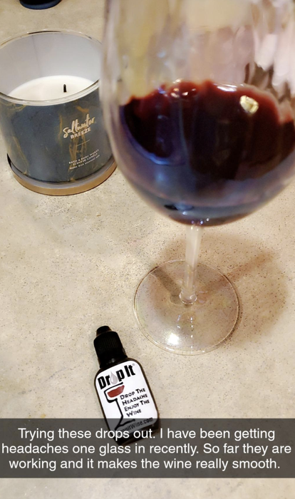 A reviewer’s image of a glass of red wine with a bottle of Drop It, accompanied by a caption explaining how it’s been effective