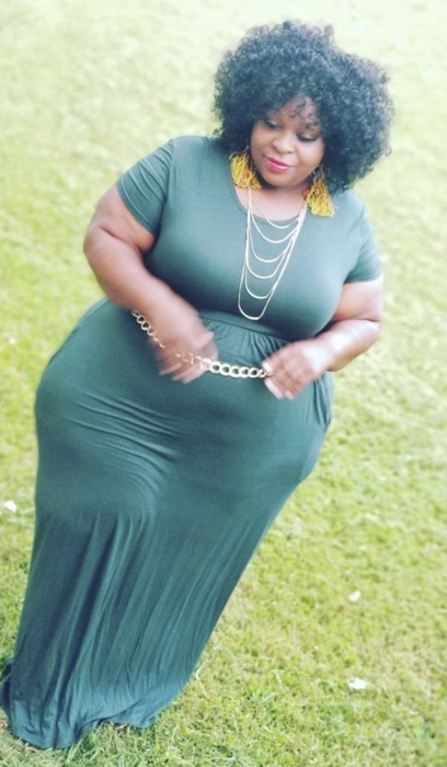 A reviewer in an emerald green maxi dress