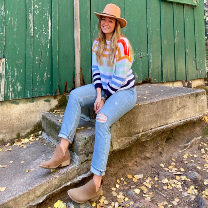 A reviewer showcasing the rainbow striped sweater