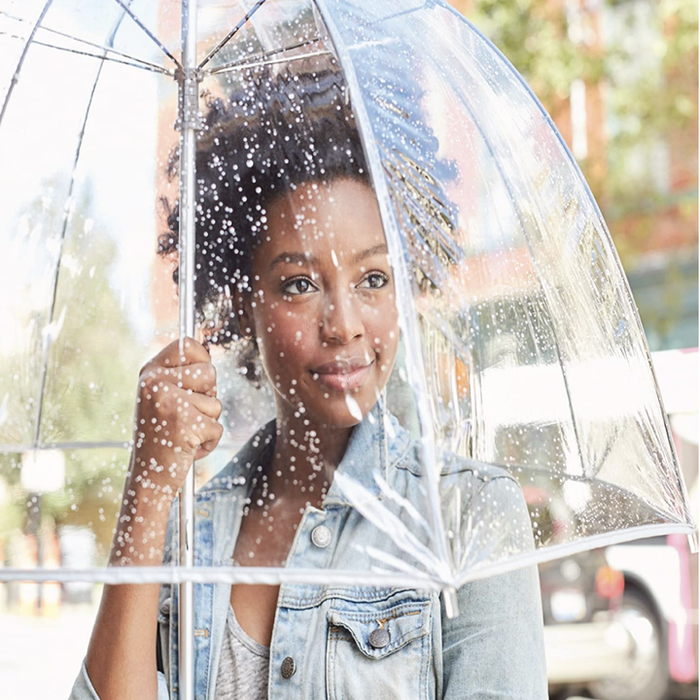 A model carrying a transparent umbrella.