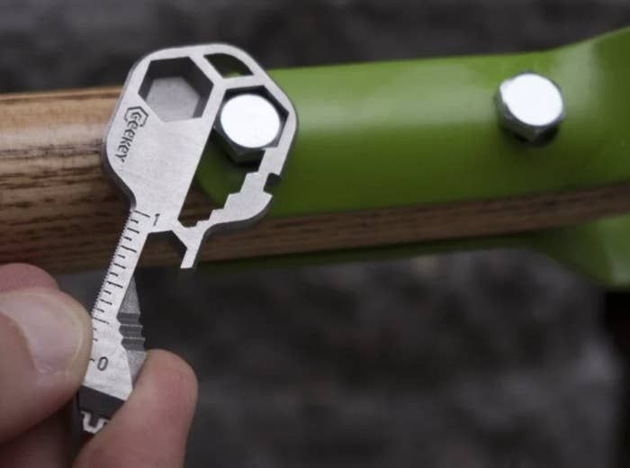 A compact steel key-shaped tool featuring multiple grooves and measurements