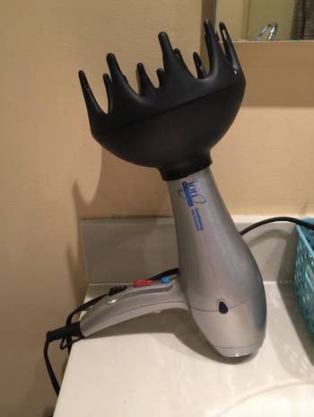 the black wide-tooth diffuser attachment on a standard hair dryer