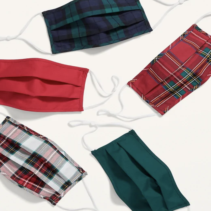 A collection of five masks in an assortment of plaid patterns and solid colors, featuring dark green and red hues