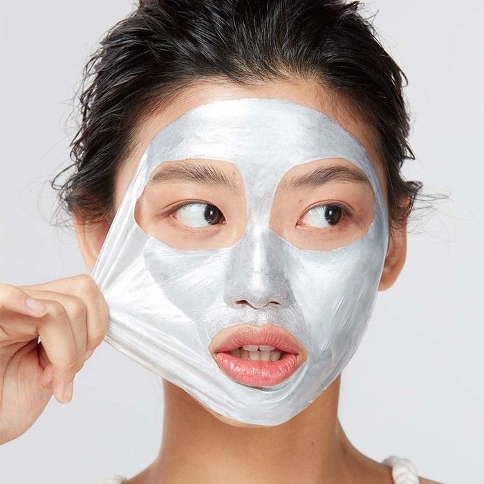 Model removing a shimmering face mask