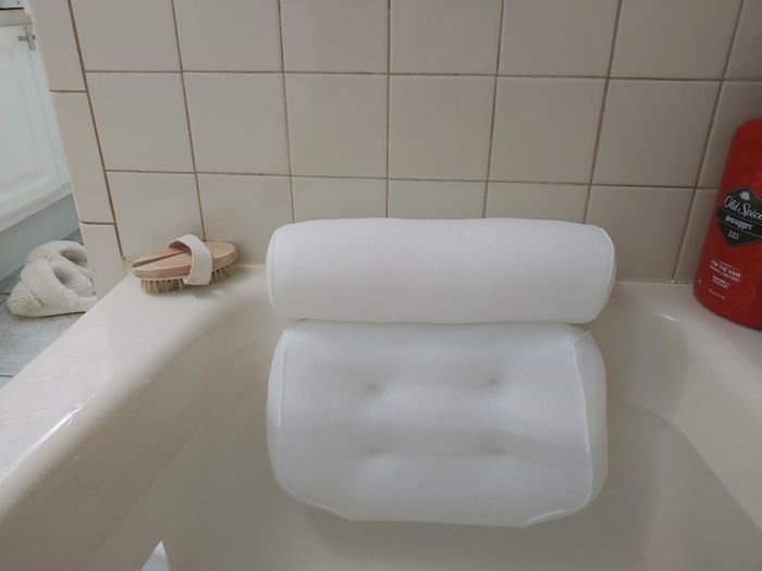 The pillow resting in a filled bathtub