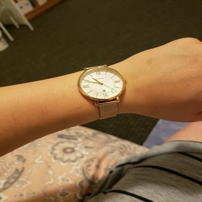 Reviewer showcasing a rose gold mesh Fossil watch on their left wrist