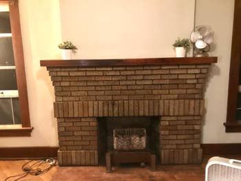 A customer's review photo of their fireplace mantel, now clean and free of soot stains after using the fireplace cleaner.