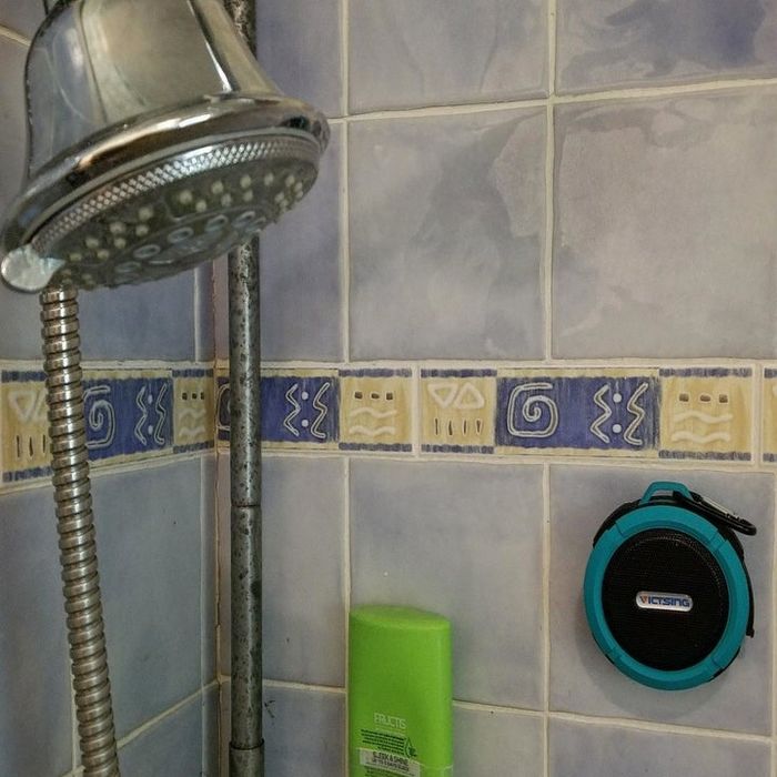 The speaker suctioned onto a shower wall