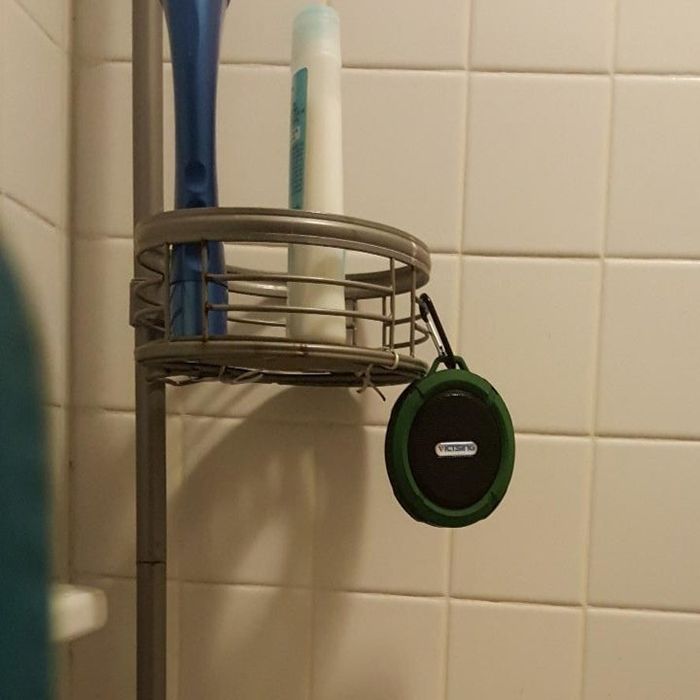 The speaker hanging from a shelf in the shower
