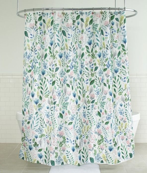 The floral shower curtain hanging, brightening up the bathroom space.