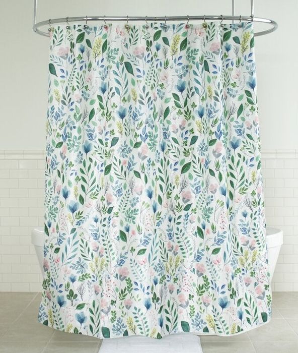 The floral shower curtain hanging, brightening up the bathroom space.