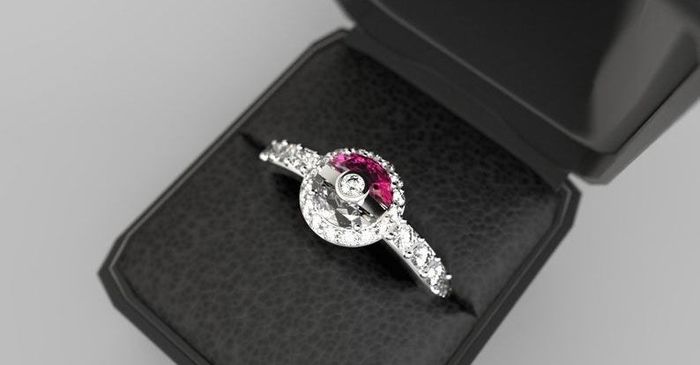 A ring displayed in a ring box, featuring a diamond-studded band and a red-and-white Poké Ball design at its center