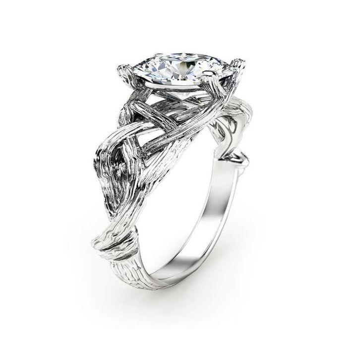 A side view of a silver moissanite ring with a band crafted to resemble intertwining branches