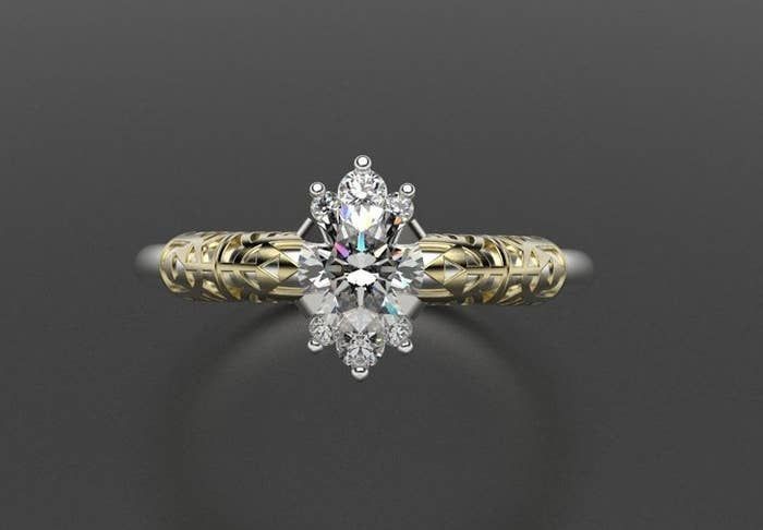 A ring featuring a white center stone and gold accents on the band, intricately designed to resemble the Triforce from "The Legend of Zelda" series