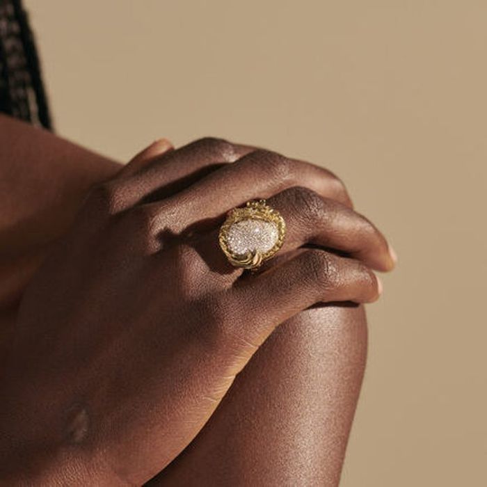 A model displaying the ring, resting their hand gracefully on their shoulder