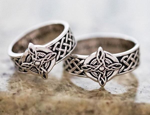 A set of coordinating silver rings featuring a detailed Celtic pattern on the band and center, complemented by an engraved interior.