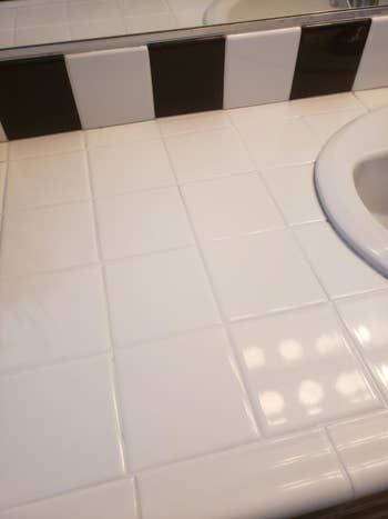 The same white tile counter now looking fresh, brand new, and spotless.