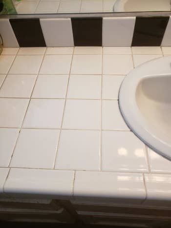 A tile counter with grout that has yellowed and become stained.