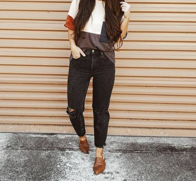 Photo of the reviewer wearing the dark tan slip-on mules.