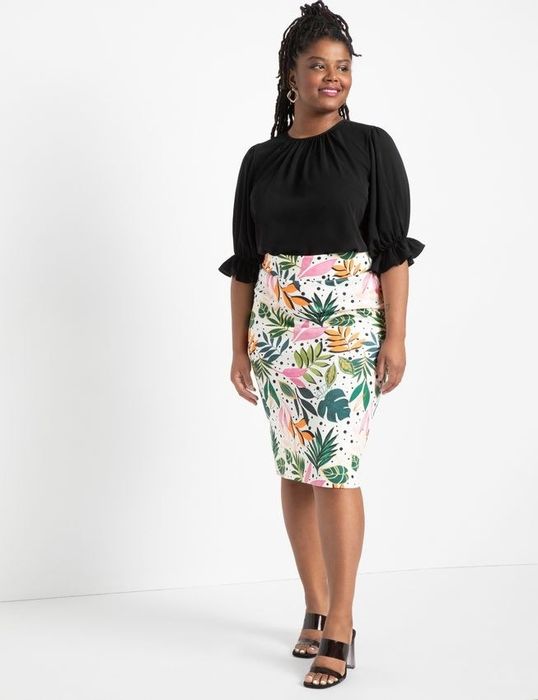 The model wears a floral skirt.