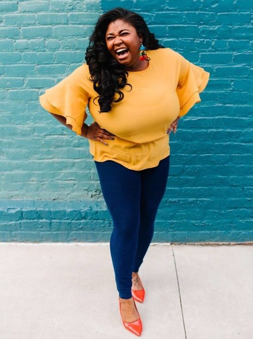 Reviewer wearing a bright yellow top with a crew neckline, extending past the waist