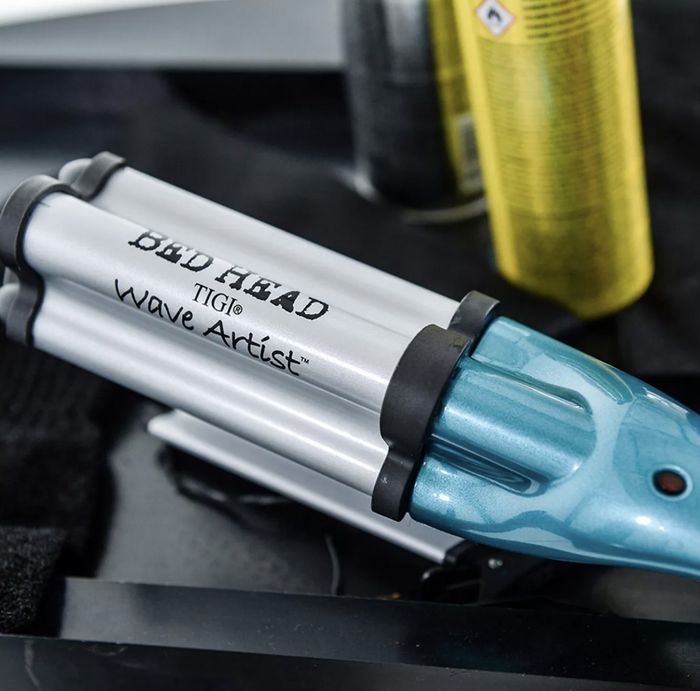 A heat-styling tool alongside a can of hairspray