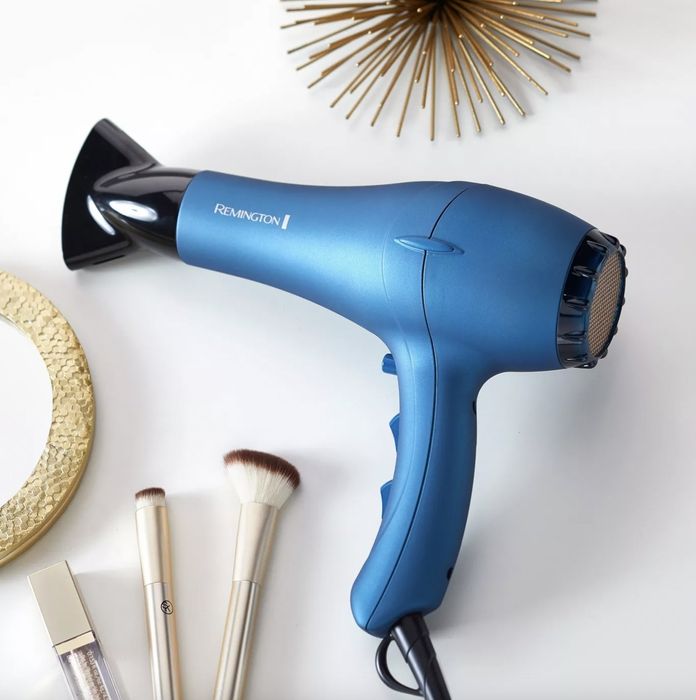 A blue blow-dryer paired with makeup brushes and a mirror
