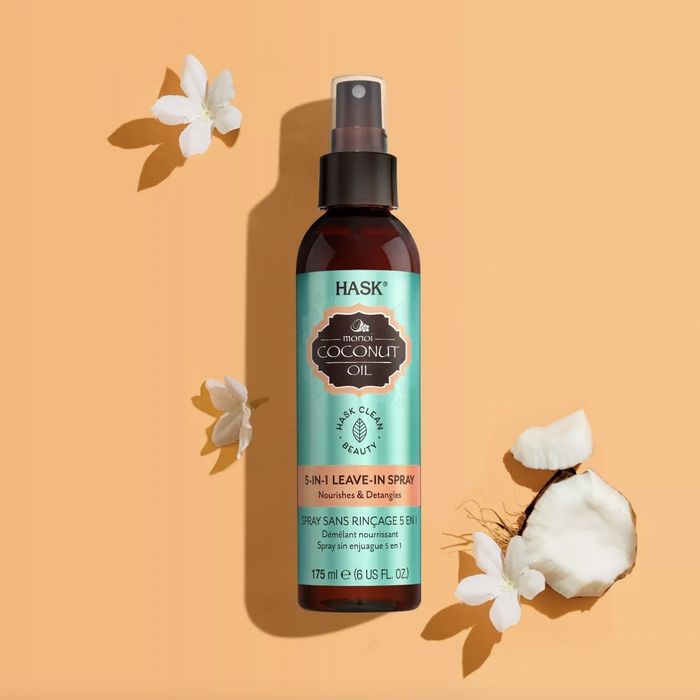 A bottle of leave-in spray with coconut pieces