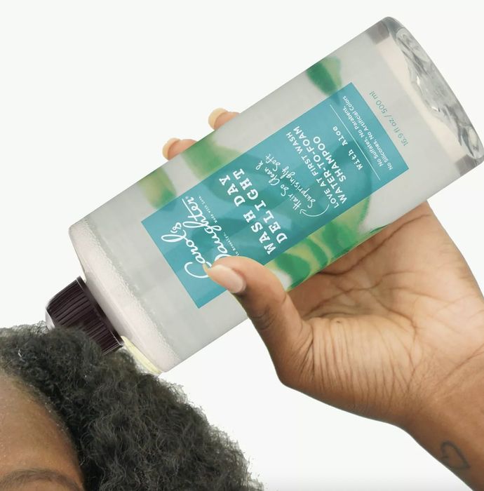 A woman massaging shampoo into her hair