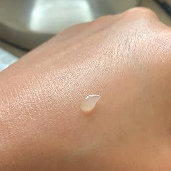 a dollop of transparent sunscreen on the reviewer's hand